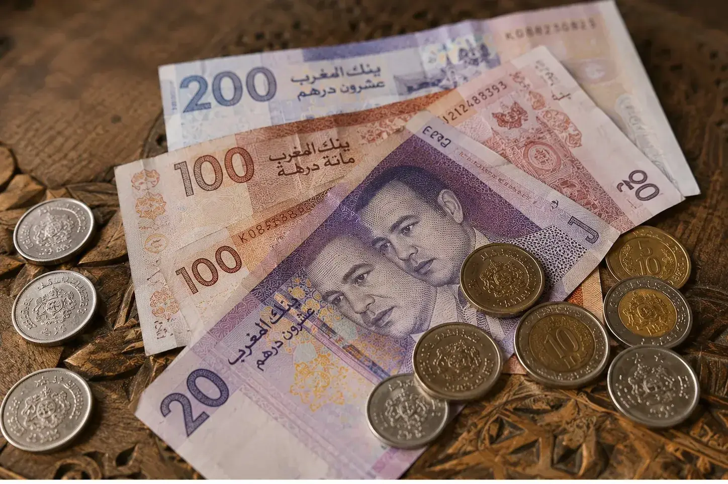 Billets et pièces en dirhams marocains sur une surface en bois
